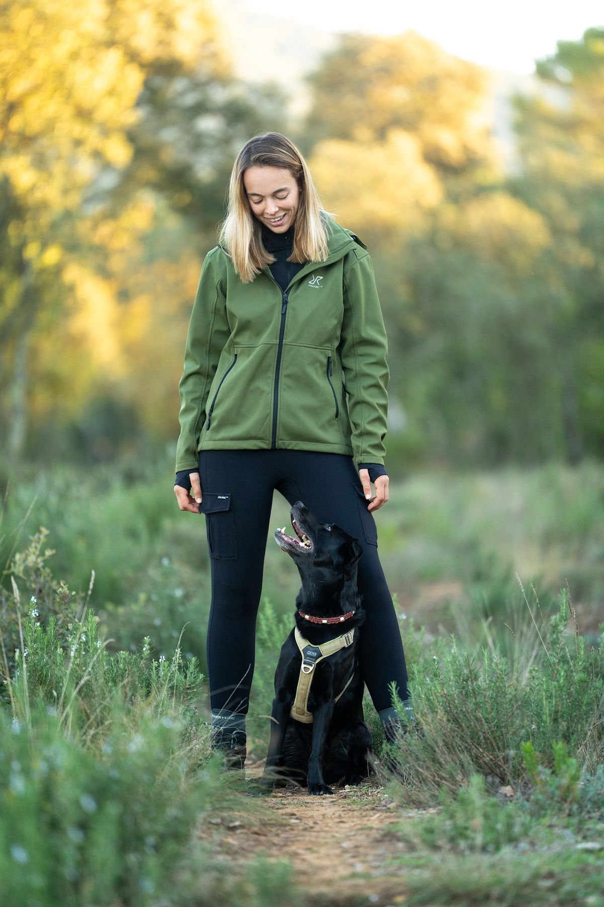 Marine Goovaerts en seance avec un chien en harnais sur un sentier, autour de Jouques