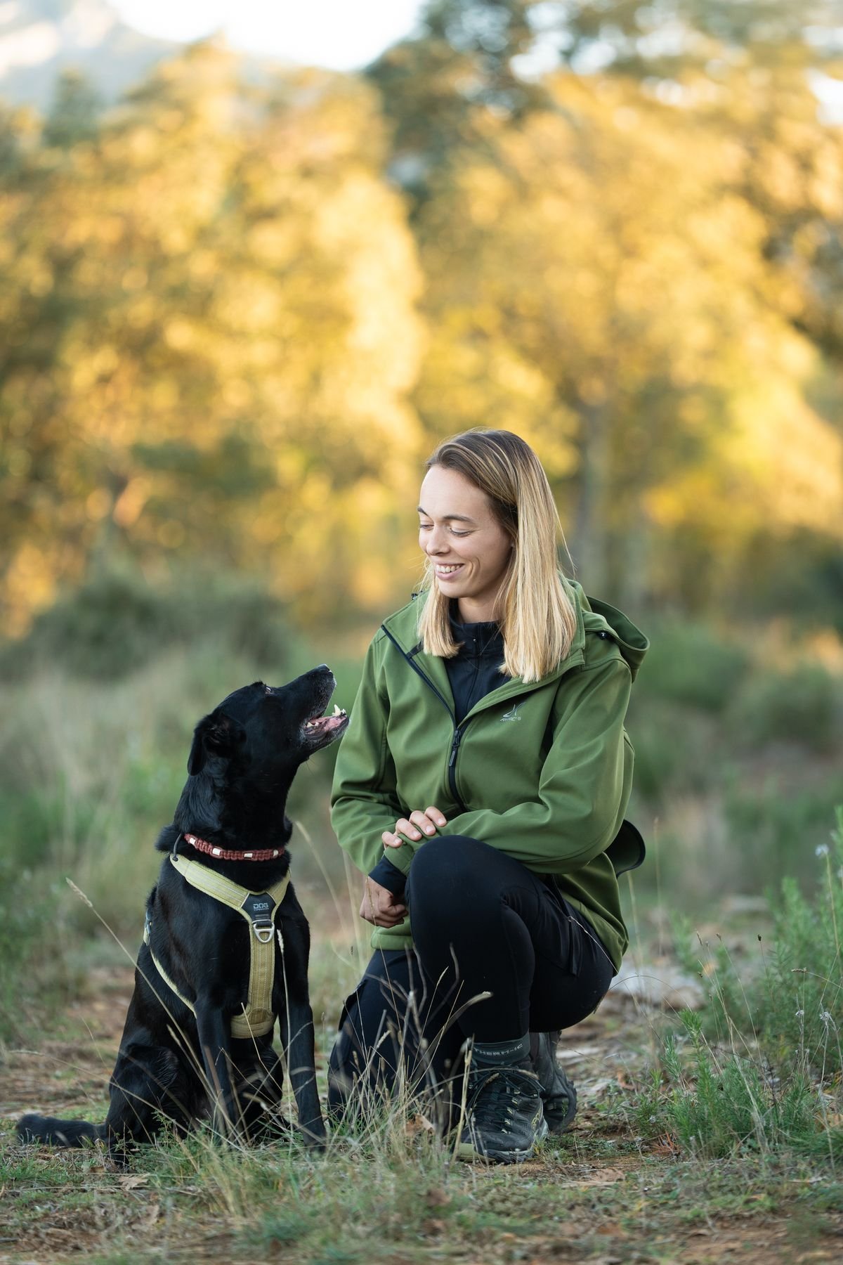 Marine Goovaerts, éducatrice comportementaliste canin, accroupie auprès de son chien près de Peyrolles-en-Provence